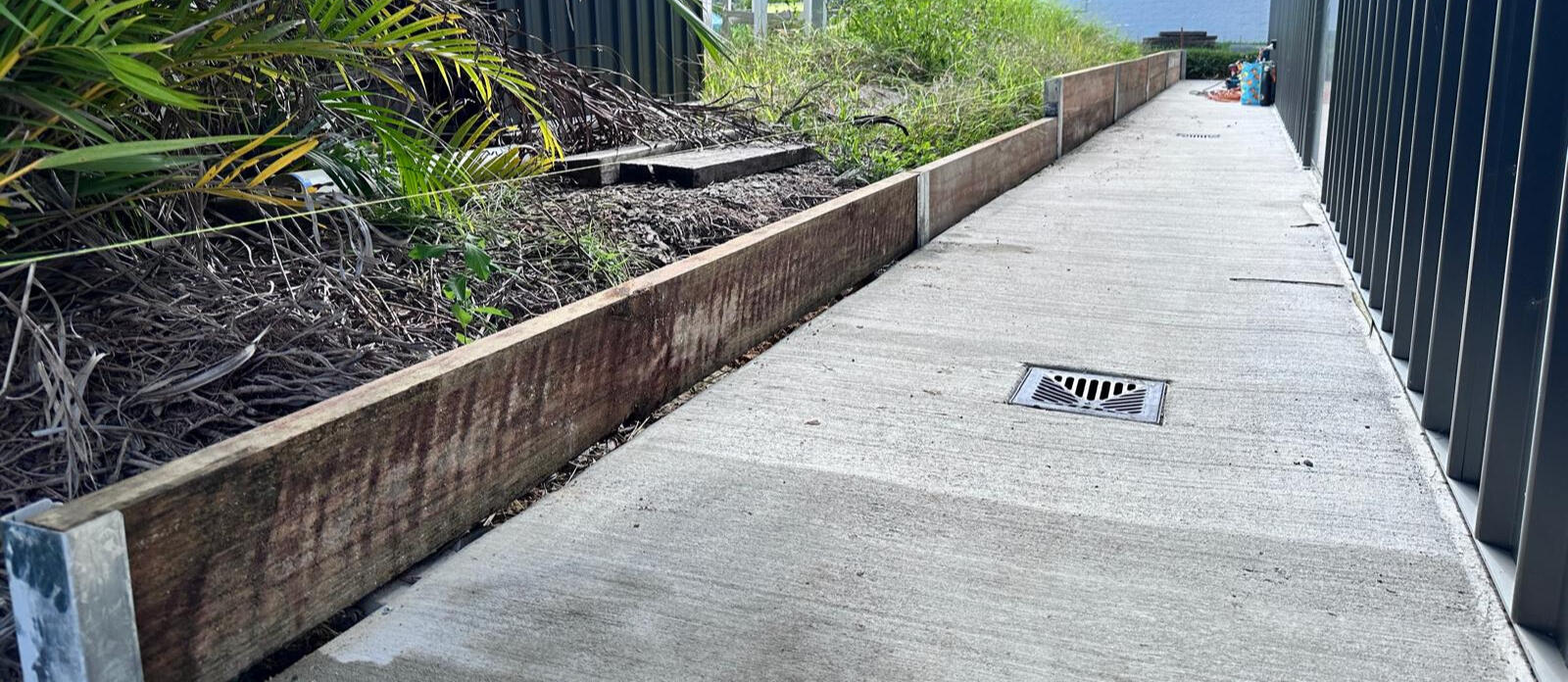Concrete Path and Timber Edging Installation by Brett Handyman – Noosa QLD Timber garden edging and concrete path with drainage installed along side yard in Noosa QLD